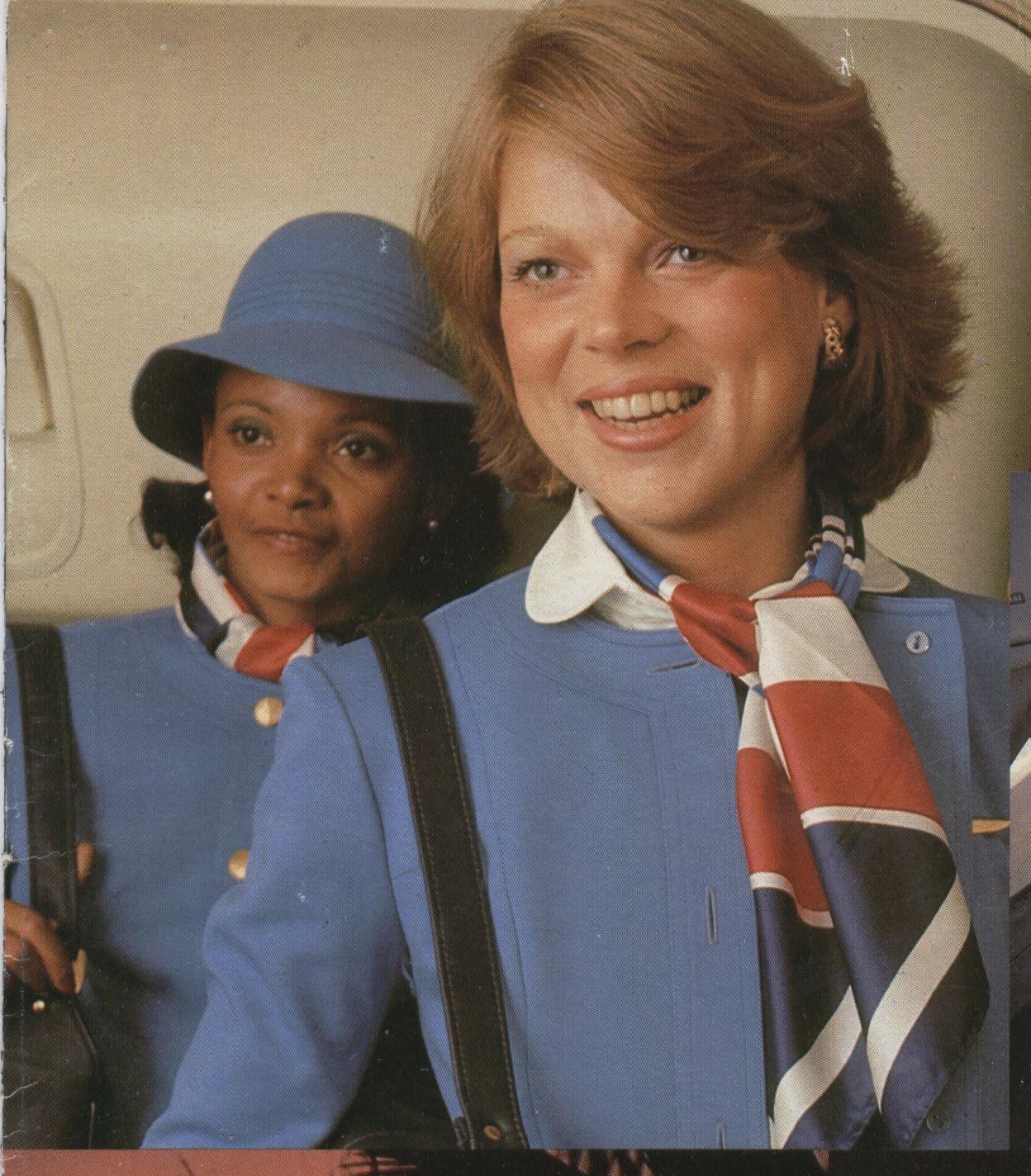 1977 Pan Am flight attendant Jennifer Andrews (left) and colleague pose in the doorway of a 747.  Their uniform was designed by Hollywood costume designer, Edith Head and introduced in 1975. 